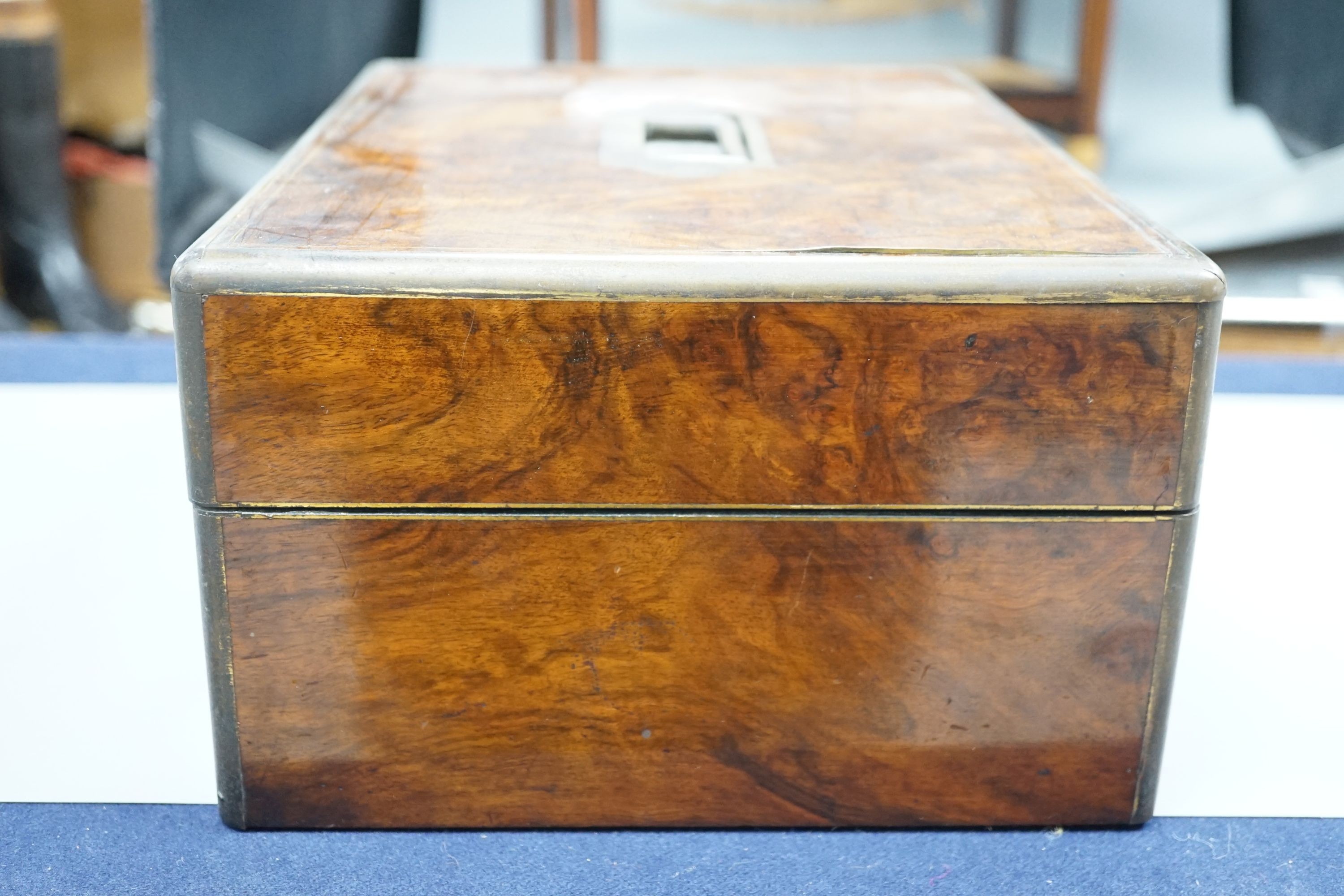 A Victorian brass mounted burr walnut toilet box, fitted with glass jars with electroplated tops, Width 30 cms. Ivory mounted items included